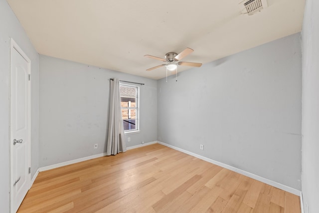 unfurnished room with light wood finished floors, baseboards, visible vents, and a ceiling fan