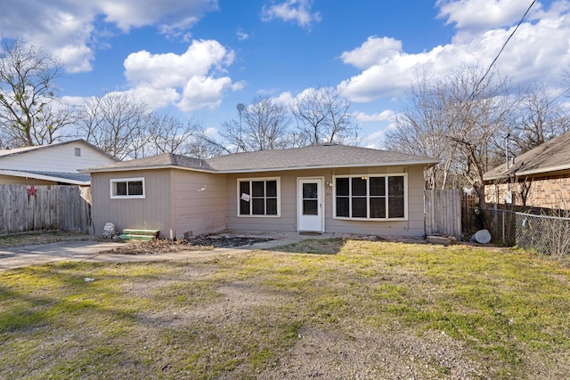 back of house featuring a yard and fence