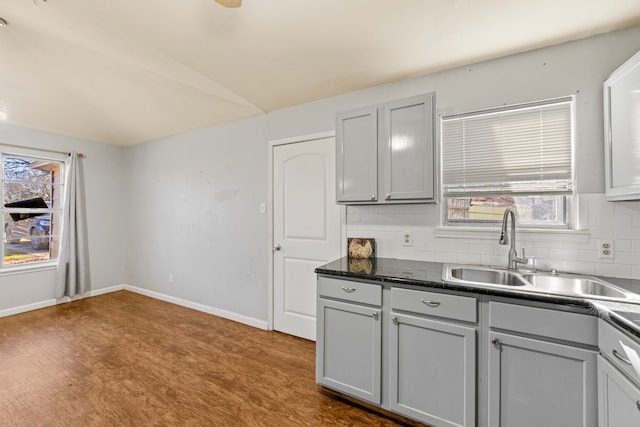 kitchen with plenty of natural light, dark countertops, a sink, and gray cabinetry