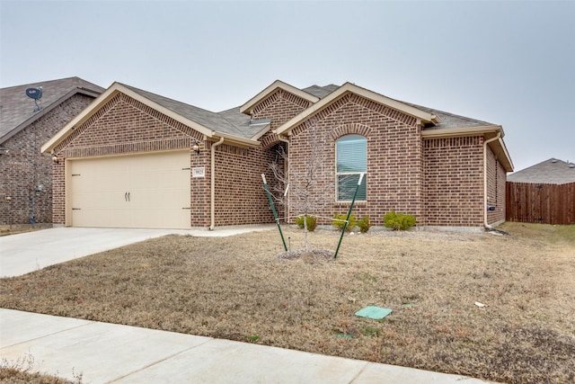 ranch-style home featuring a garage, brick siding, driveway, and fence