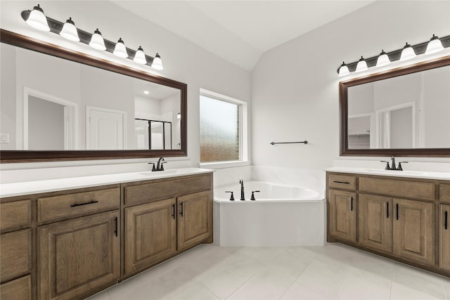 full bathroom with a bath, tile patterned flooring, vaulted ceiling, a stall shower, and vanity