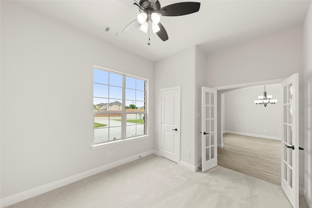 unfurnished bedroom featuring carpet floors, french doors, ceiling fan with notable chandelier, baseboards, and visible vents