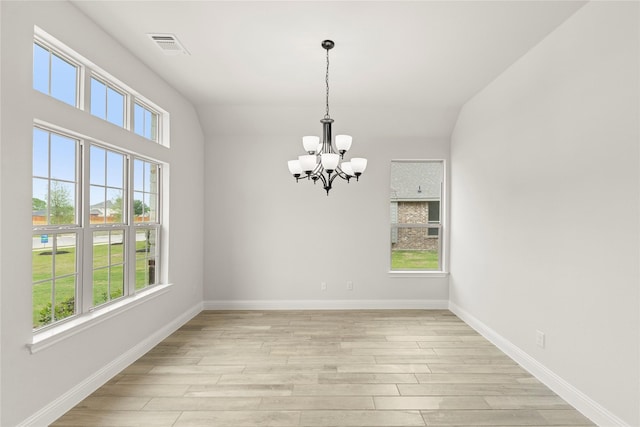 unfurnished dining area featuring baseboards, an inviting chandelier, visible vents, and light wood-type flooring