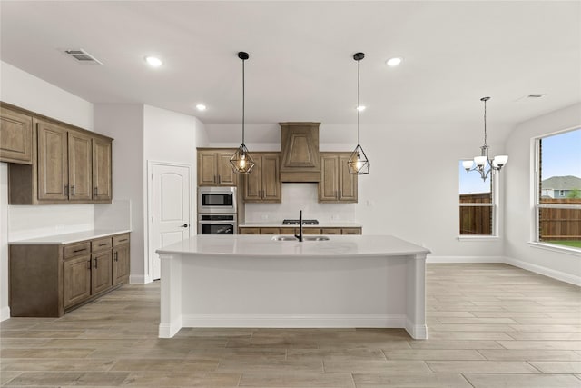 kitchen with premium range hood, wood finish floors, appliances with stainless steel finishes, and visible vents