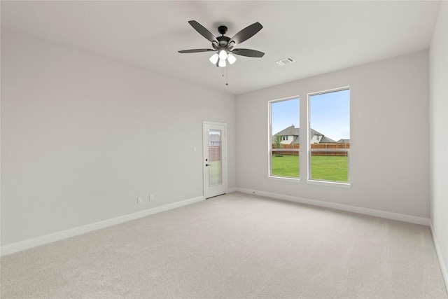 unfurnished room featuring a ceiling fan, baseboards, visible vents, and light carpet