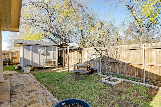 view of yard featuring an outbuilding, a fenced backyard, and a storage unit