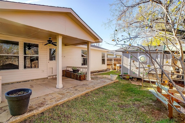 view of yard with a patio, fence, an outdoor structure, and ceiling fan