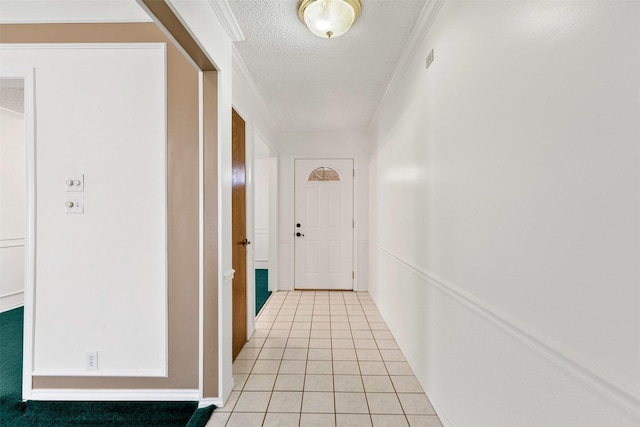 hall with visible vents, light tile patterned flooring, crown molding, and a textured ceiling