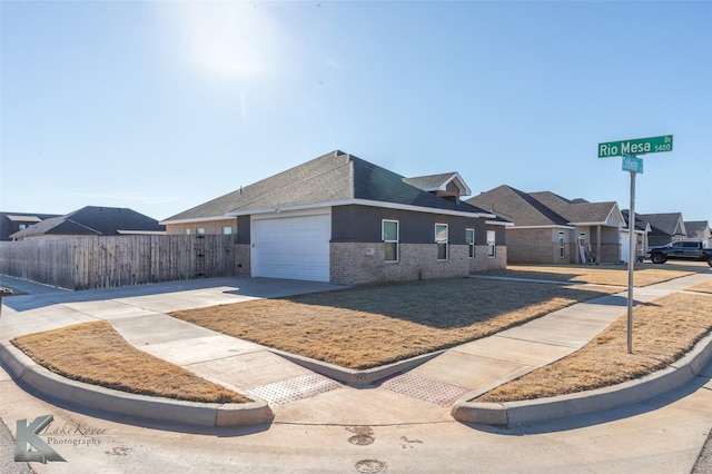 single story home featuring brick siding, an attached garage, fence, a residential view, and driveway