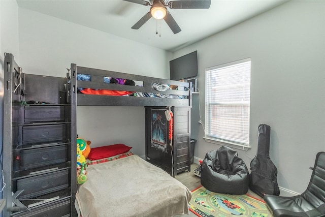 bedroom with a ceiling fan, baseboards, and wood finished floors