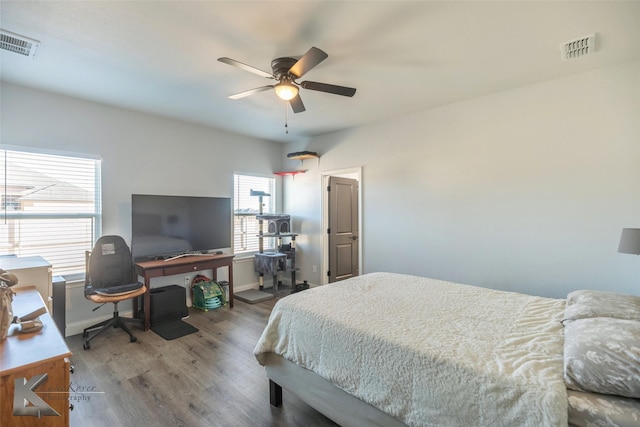 bedroom featuring a ceiling fan, wood finished floors, visible vents, and baseboards