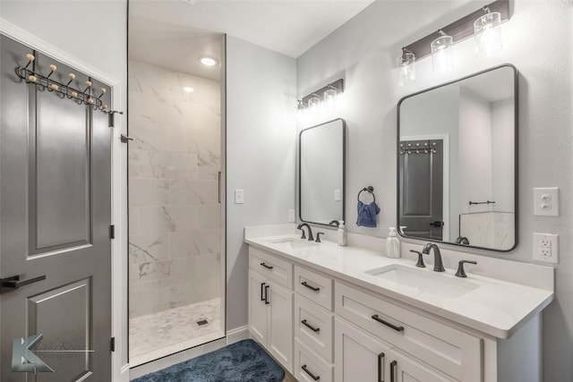 full bathroom with double vanity, a sink, and a marble finish shower