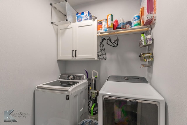 washroom featuring independent washer and dryer and cabinet space