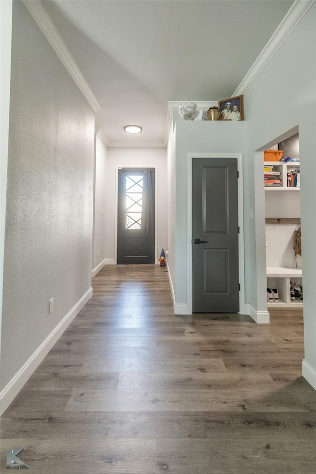 doorway with wood finished floors and crown molding