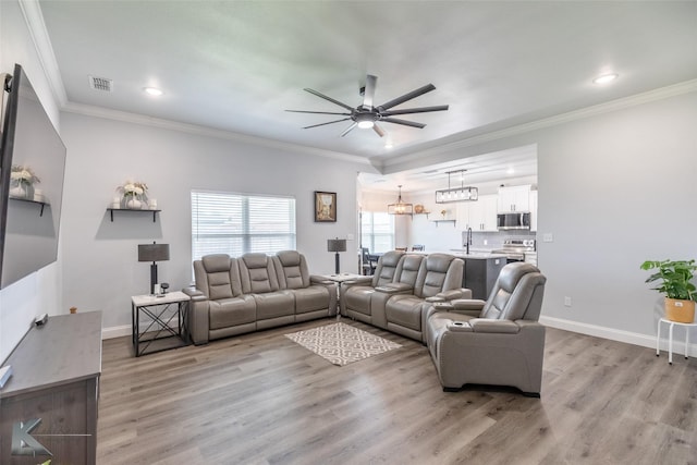 7001 Coldwater Dr, Abilene, TX 79601 - living room with ceiling fan, light wood finished floors, crown molding, baseboards, and a chandelier