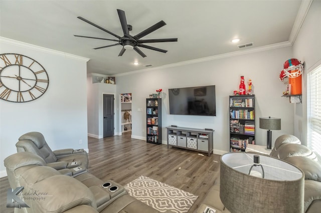 living area with baseboards, ornamental molding, and wood finished floors