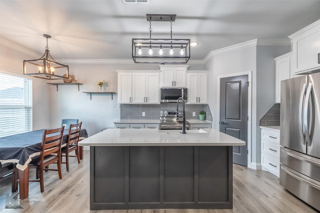7001 Coldwater Dr, Abilene, TX 79601 - kitchen featuring appliances with stainless steel finishes, light countertops, white cabinets, tasteful backsplash, and a chandelier