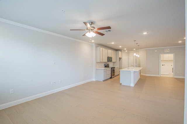 kitchen featuring visible vents, hanging light fixtures, a kitchen island with sink, stainless steel appliances, and light countertops