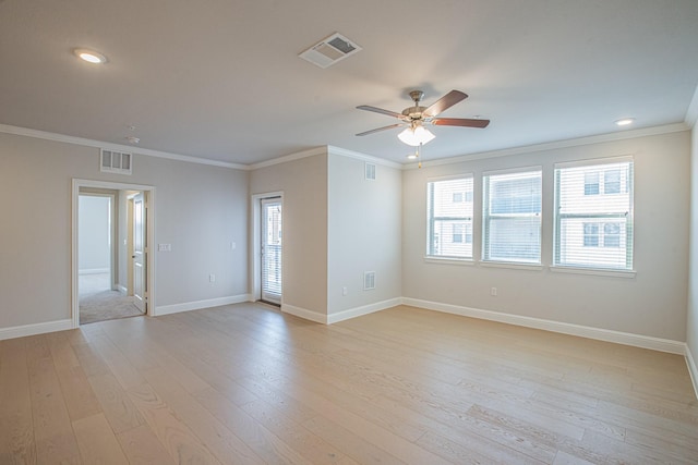 spare room with light wood-style floors, a healthy amount of sunlight, and visible vents