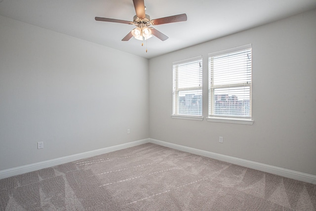 spare room with ceiling fan, carpet flooring, and baseboards