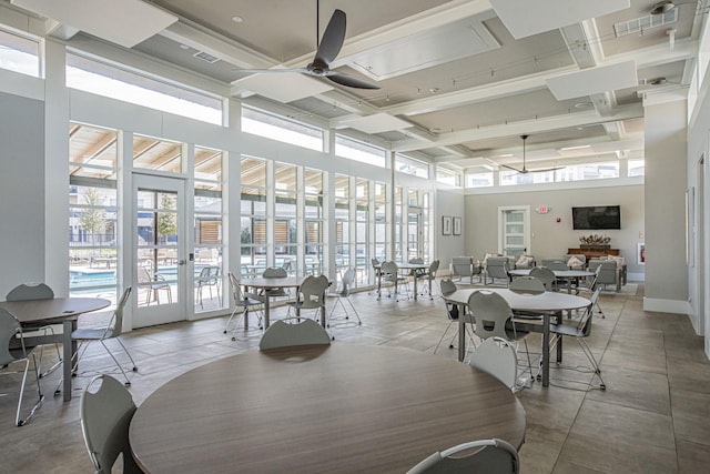 dining area with light tile patterned floors, ceiling fan, a high ceiling, and baseboards