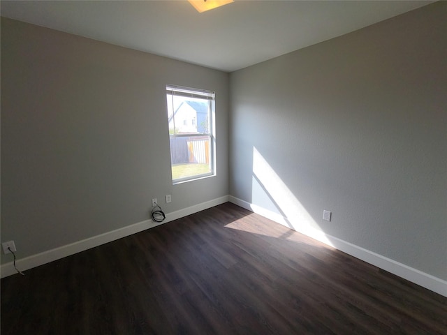 unfurnished room featuring dark wood finished floors and baseboards