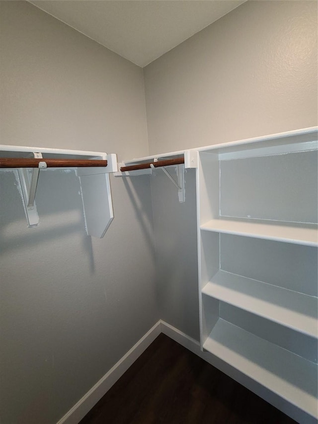 spacious closet with dark wood-type flooring