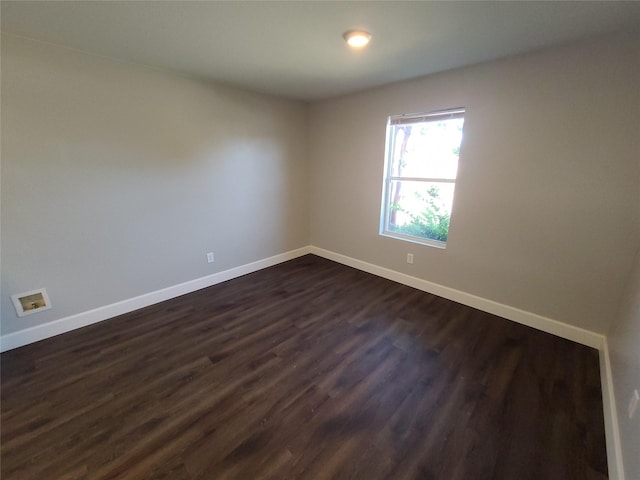 empty room with baseboards and dark wood-style flooring