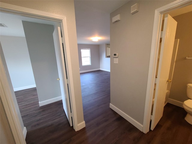 corridor with baseboards and dark wood finished floors