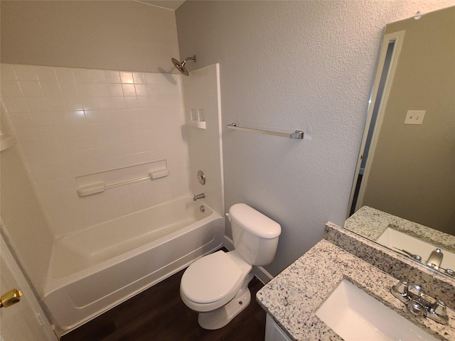 full bathroom featuring shower / washtub combination, a textured wall, toilet, vanity, and wood finished floors