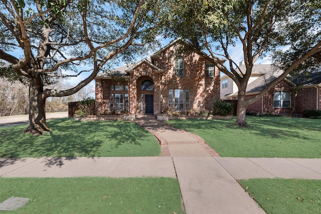 view of front of home featuring a front lawn and brick siding