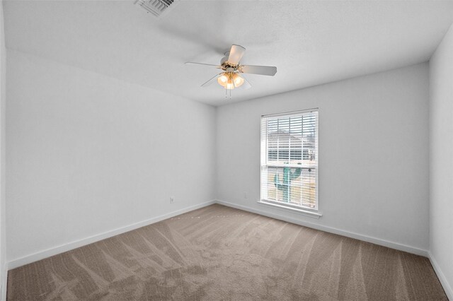 unfurnished room featuring a ceiling fan, visible vents, baseboards, and carpet flooring