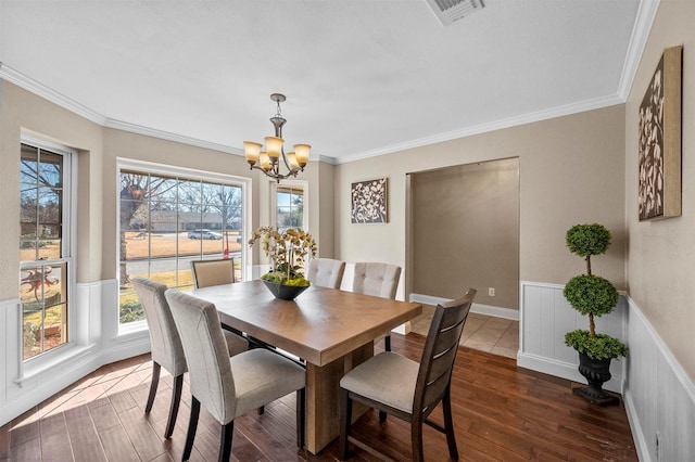 dining room with visible vents, a wainscoted wall, wood finished floors, and ornamental molding