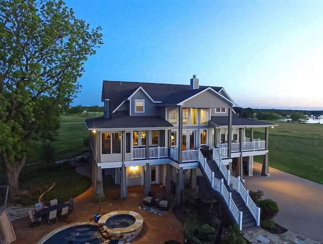 rear view of property featuring an outdoor fire pit, a patio, stairway, and a balcony