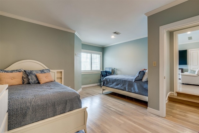 bedroom featuring baseboards, visible vents, crown molding, and light wood finished floors