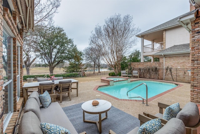 view of swimming pool with outdoor dining space, a pool with connected hot tub, a patio, fence, and outdoor lounge area