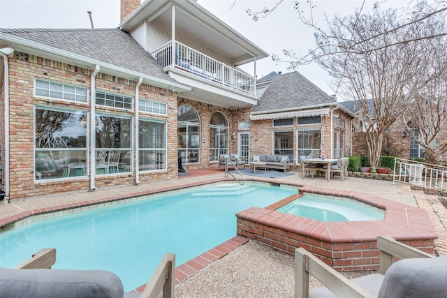 outdoor pool with a patio, an outdoor living space, and an in ground hot tub