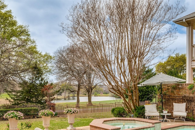 view of pool featuring an in ground hot tub, a water view, and fence