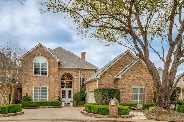 5415 Preston Fairways Cir, Dallas, TX 75252 - traditional-style house with an attached garage, french doors, a chimney, concrete driveway, and brick siding