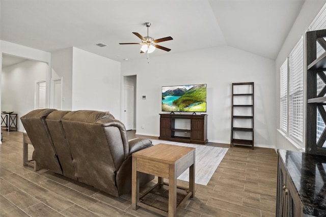 living area featuring wood finish floors, visible vents, lofted ceiling, and baseboards