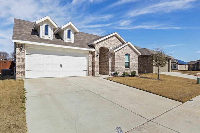 view of front of home featuring a garage, driveway, brick siding, and a front yard