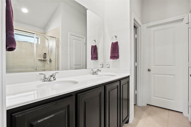 full bath with double vanity, a stall shower, a sink, and tile patterned floors