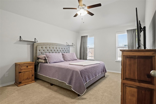 bedroom with light carpet, a ceiling fan, and baseboards