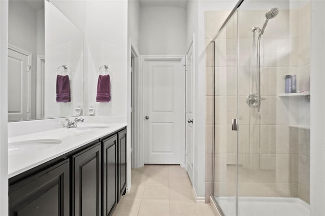 full bath featuring double vanity, a shower stall, a sink, and tile patterned floors