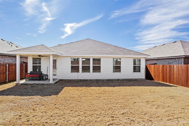 rear view of house with a yard, a patio area, a fenced backyard, and ceiling fan