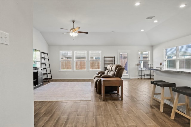 sitting room with lofted ceiling, visible vents, recessed lighting, and wood finished floors