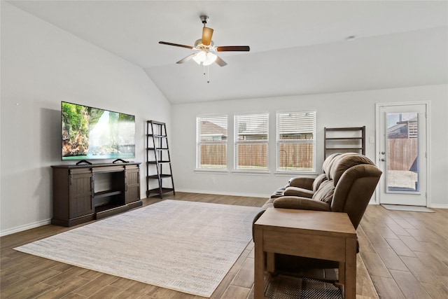 living area with a ceiling fan, lofted ceiling, baseboards, and wood finished floors