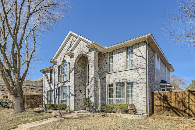 view of front of property featuring fence and brick siding