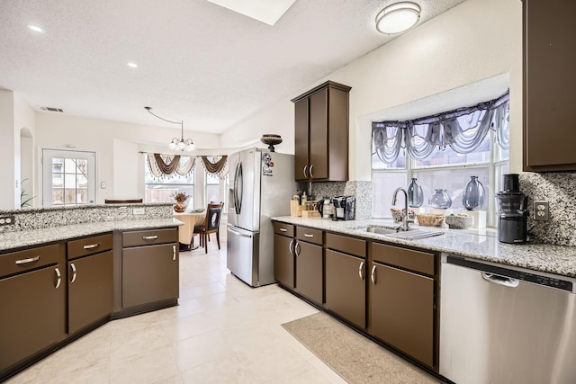 kitchen featuring light stone countertops, dark brown cabinetry, visible vents, and stainless steel appliances