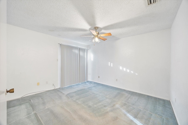 carpeted empty room with ceiling fan, a textured ceiling, visible vents, and baseboards